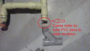 Un tube de PVC cassé net dans la dalle de béton